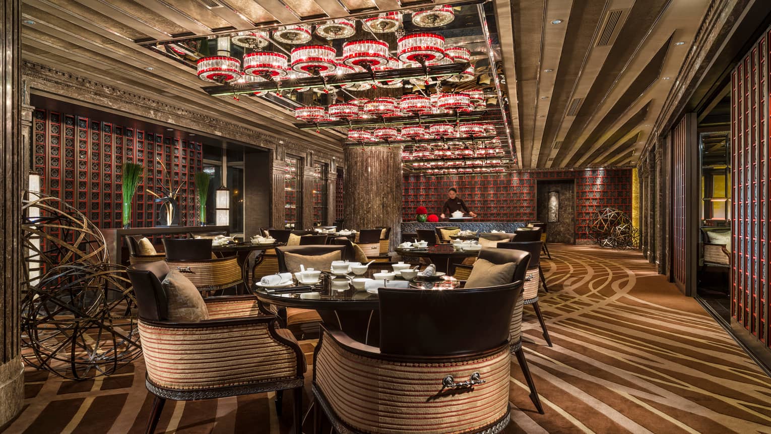 Large curved dining chairs in elegant round dining tables under small red crystal lights in Cai Yi Xuan restaurant