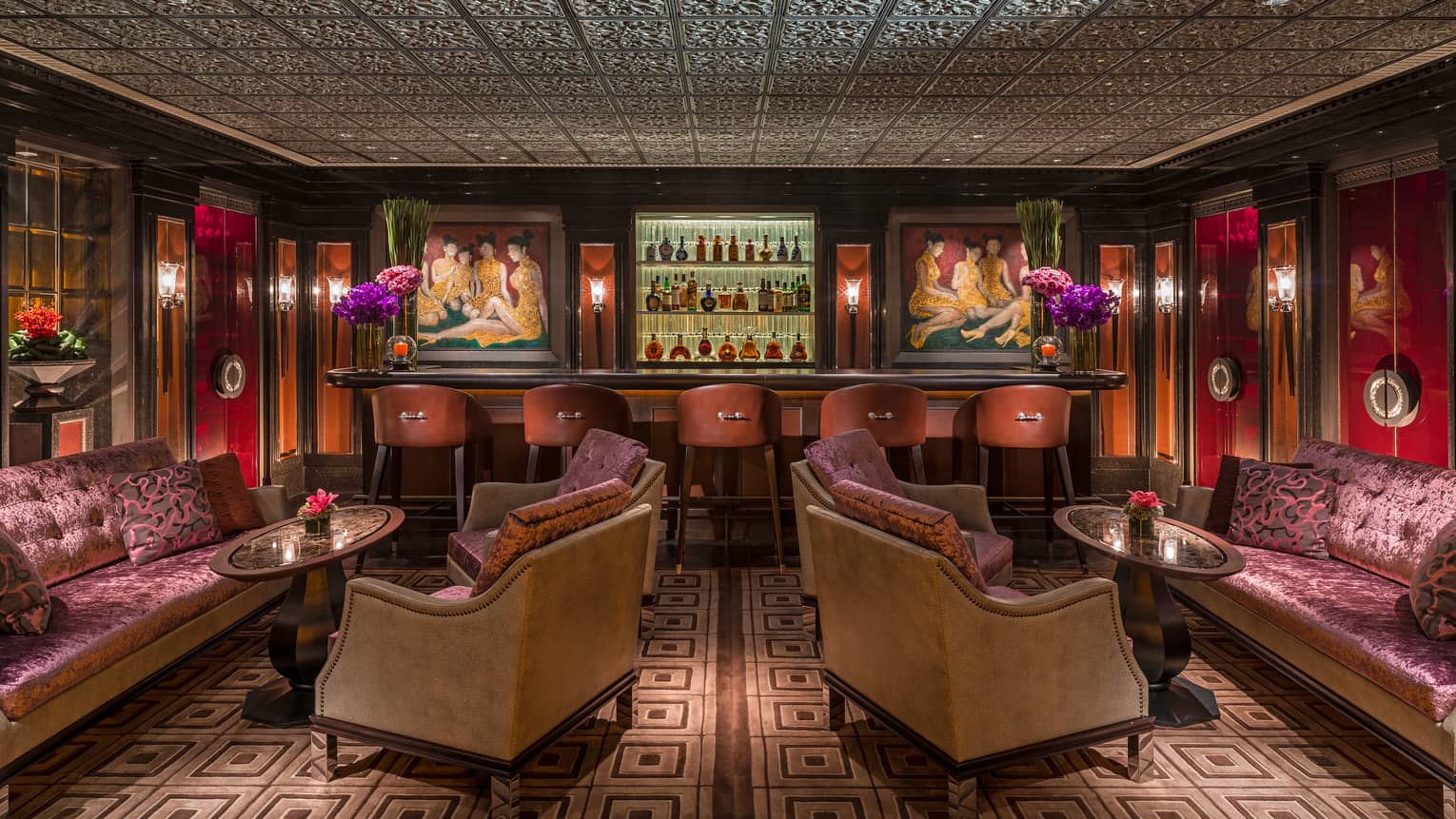 Purple crushed-velvet sofas, brown armchairs in front of bar with colourful oil paintings