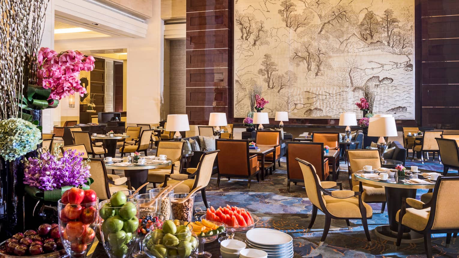 Opus Lounge tables and chairs in sunny dining room, table with fresh fruit platters, apples in glass vases
