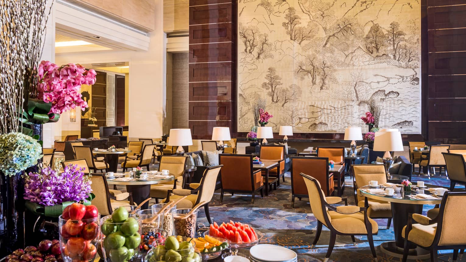 Opus Lounge tables and chairs in sunny dining room, table with fresh fruit platters, apples in glass vases