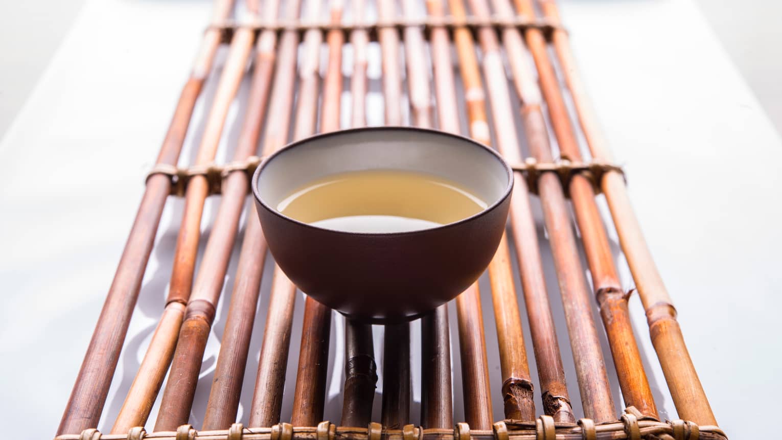 Close-up of small bowl-shaped tea cup with tea