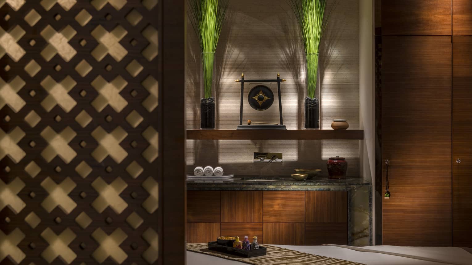 Carved wood wall, shelf with Chinese art, rolled towels