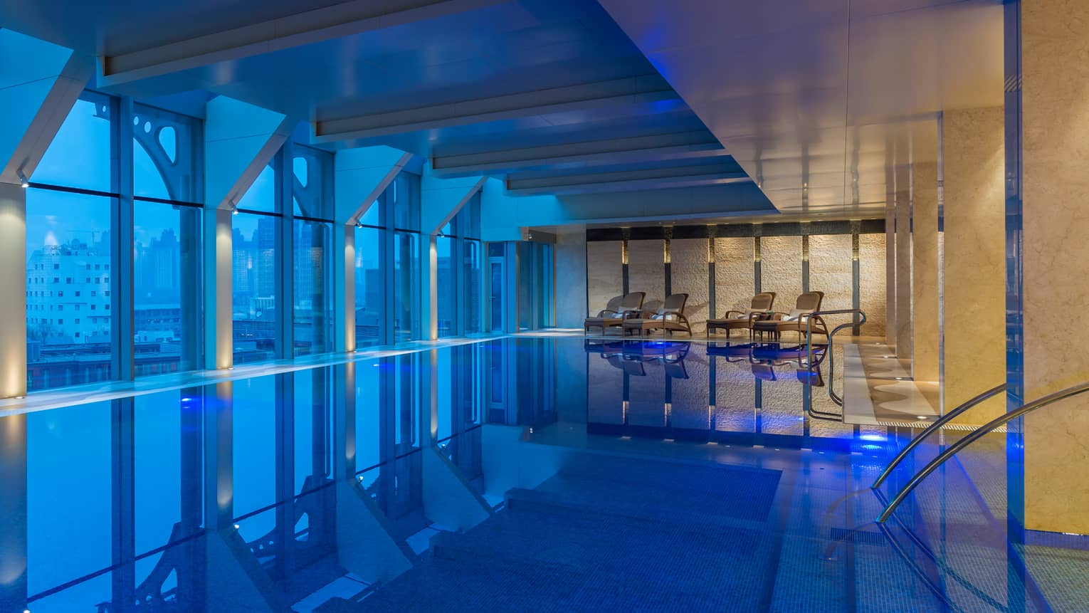 Indoor swimming pool along window at dusk