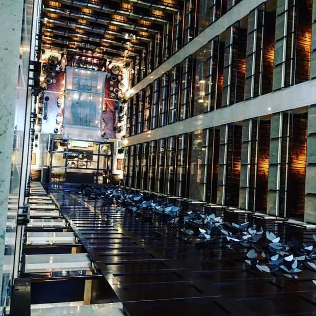 View looking down multi-storey atrium to hotel lobby, steel butterflies along wall